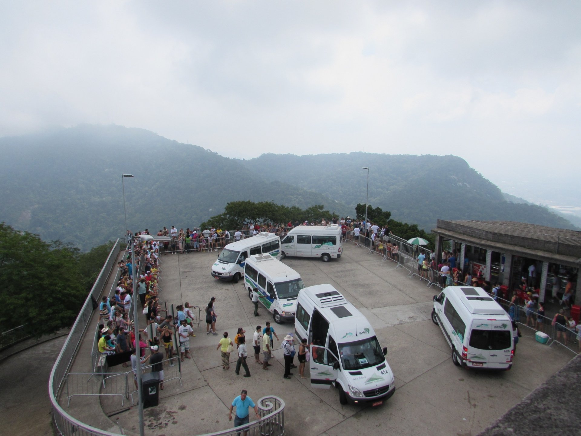 Vans oficiais Paineiras-Corcovado no ponto de embarque, com visitantes em fila