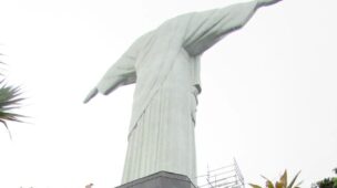 Estátua do Cristo Redentor vista de baixo, com andaime ao lado do pedestal