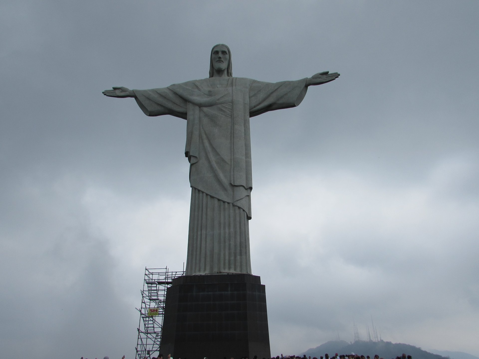 Estátua do Cristo Redentor inteira, sob nuvens carregadas, no topo do Corcovado